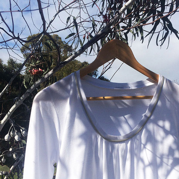 Women's white winter organic cotton nightgown. Australian made. Long sleeved light white cotton nightie with mid calf length.